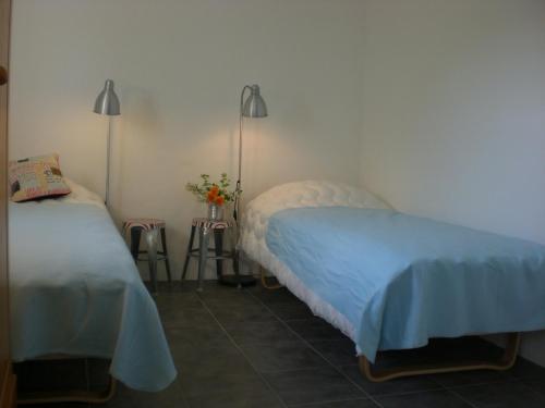 BorrbyOla-Nils Gård的一间卧室设有两张床,墙上有两盏灯。