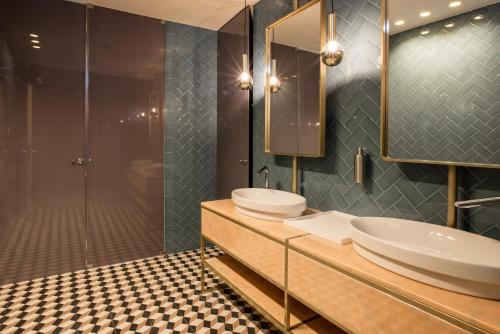 波尔图波尔图埃尔阿尔马达酒店的一间带两个盥洗盆和淋浴的浴室