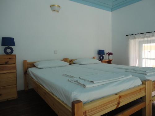 哈尔基岛Halki Townhouse的卧室配有一张带白色床单的大床和窗户。