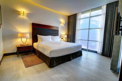 达卡太空公寓式酒店的酒店客房设有一张床和一个大窗户