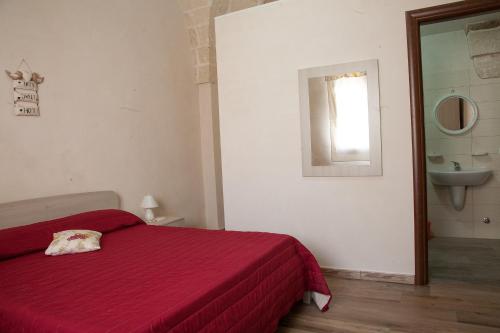 阿韦特拉纳Le 5 Volte的卧室配有红色的床和水槽