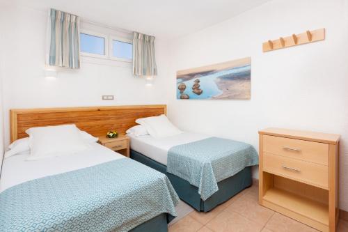 英格兰海滩MUR Apartamentos Buenos Aires Gran Canaria的酒店客房设有两张床和一张桌子。