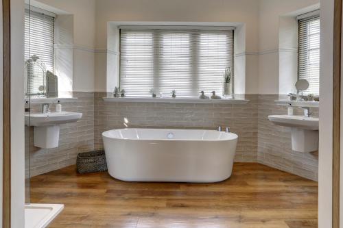 塞特尔猎鹰庄园酒店的浴室设有白色浴缸及两个盥洗盆
