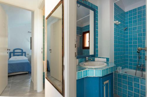 巴哈撒丁岛Residence I Cormorani Alti的蓝色的浴室设有水槽和镜子
