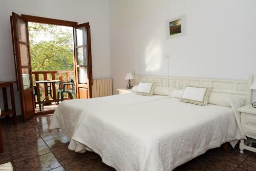 柯米拉斯索拉托尔酒店的一间带一张白色大床的卧室和一个阳台