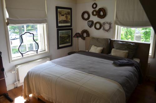 Sleeuwijk比雅尼克住宿加早餐旅馆 的一间卧室设有一张大床和两个窗户。