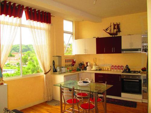 康提康提安甜蜜别墅的厨房配有桌椅和窗户。