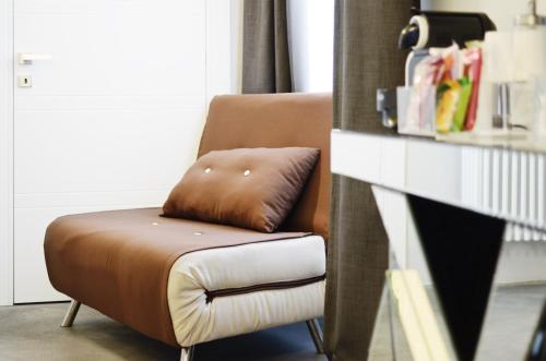 都灵卡斯泰洛广场套房公寓式酒店的棕色椅子和棕色枕头