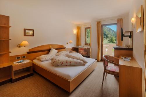 坎波图雷斯梅尔酒店的一间卧室配有一张床、一张书桌和一个窗户。