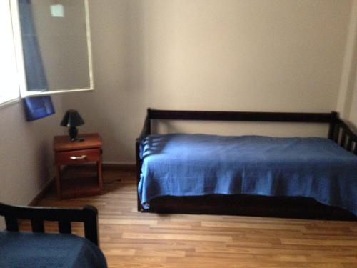 梅塞德斯Apartamento en el centro de mercedes URUGUAY的一间卧室配有蓝色的床和床头柜