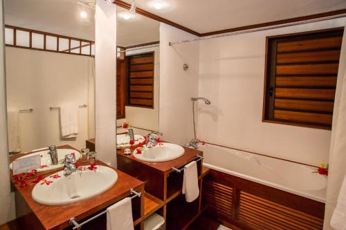 VaoOure Lodge Beach Resort的浴室配有2个盥洗盆和1个浴缸。