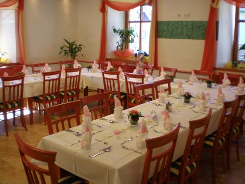 Sankt GeorgenGästehaus Freitag das kleine Hotel的配有桌椅和粉红色餐巾的房间