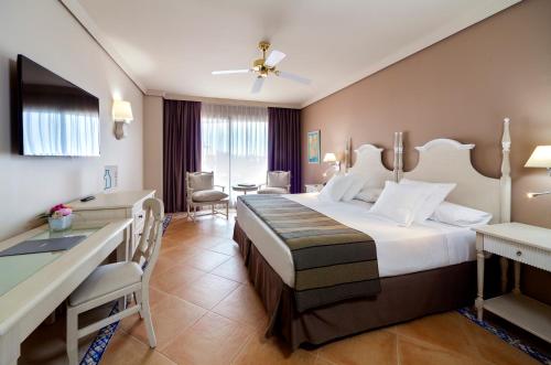 马贝拉巴瑟罗马贝拉酒店的酒店客房设有一张大床和一张书桌。