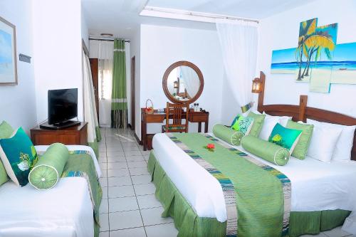 蒙巴萨航海家海滩度假酒店的酒店客房设有两张床和电视。