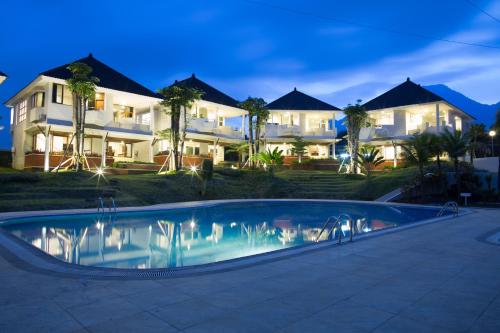 巴图萨马拉度假酒店的房屋前有游泳池的房子