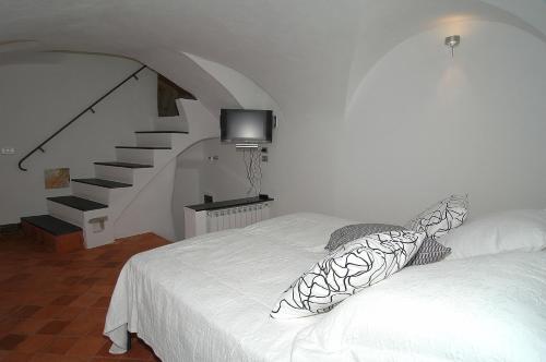 VallebonaA Ca Du Barba Ge的卧室配有白色的床和楼梯。