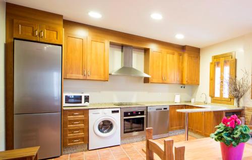 雷克纳Casa Rural Francisca的厨房配有木制橱柜、洗衣机和烘干机