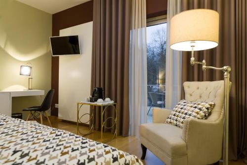 奥利维拉多霍斯比托Alva Valley Hotel的酒店的客房 - 带一张床、椅子和窗户