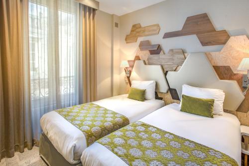 巴黎阿尔伯特王子酒店的酒店客房设有两张床和窗户。