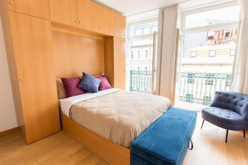 波尔图Porto 271 Mouzinho Apartamentos的卧室配有床、椅子和窗户。