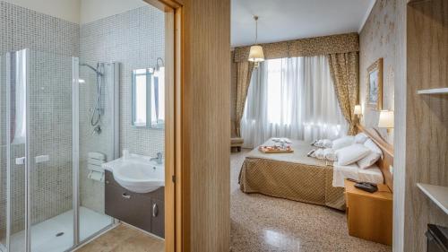 卢切拉索黎所酒店的一间带床、水槽和淋浴的浴室