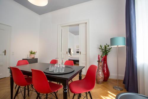 海德堡米勒斯特尔城市酒店的一间带桌子和红色椅子的用餐室