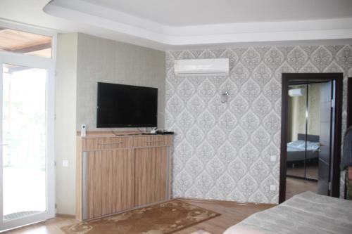 乌雷基Apartment near the Black Sea Ureki的客厅的墙上配有电视