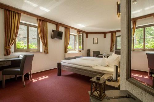 施托尔彭Burghotel Stolpen的一间卧室配有一张床、一张书桌和一面镜子