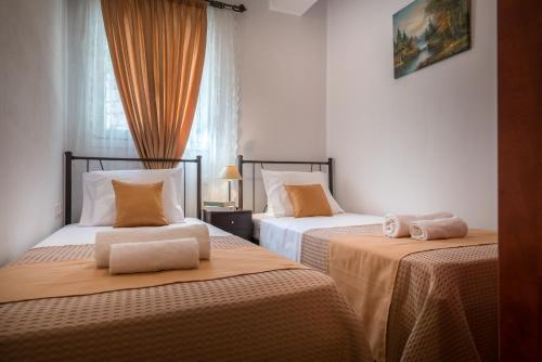 卡利地亚Aelia Villa的一间卧室配有两张带橙色床单的床