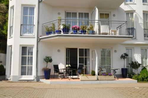 萨斯尼茨Ferienwohnung Anemone的白色的房子,设有种植了盆栽植物的阳台