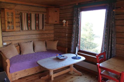 GarmoKvila Hytteutleie的小屋内带床和桌子的房间