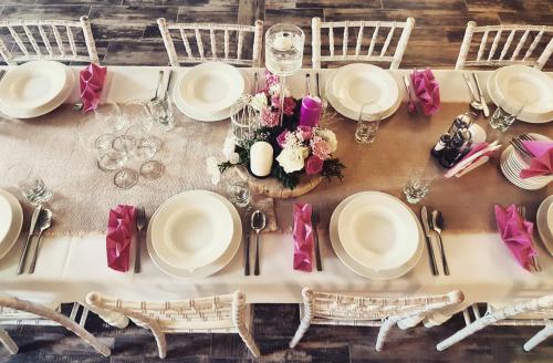 安德雷胡夫兹洛卡丽贝卡酒店的一张桌子上摆放着白色的盘子和椅子,花朵上摆放着
