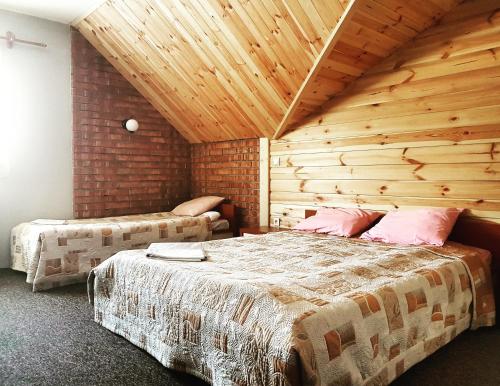 安德雷胡夫兹洛卡丽贝卡酒店的一间卧室设有两张床和木制天花板