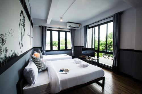 北碧北碧BY酒店的一间卧室设有两张床、一台电视和窗户。