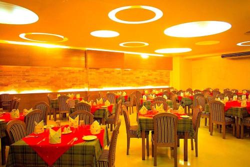 吉大港Asian SR Hotel的用餐室配有桌椅和红色餐巾
