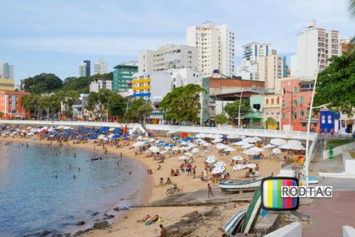 萨尔瓦多Hotel Porto Da Barra的一群人在海滩上,带遮阳伞