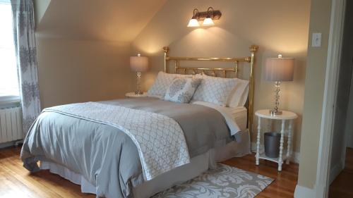 大梅勒Gîte La Belle Aventure B&B的一间卧室配有一张带两盏灯和两张桌子的床。