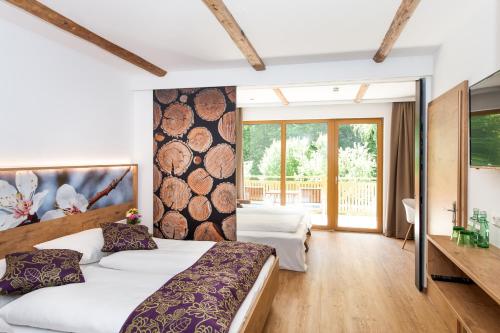 Mühldorf高萨湖白马宾馆的一间卧室配有一张大床和木制床头板