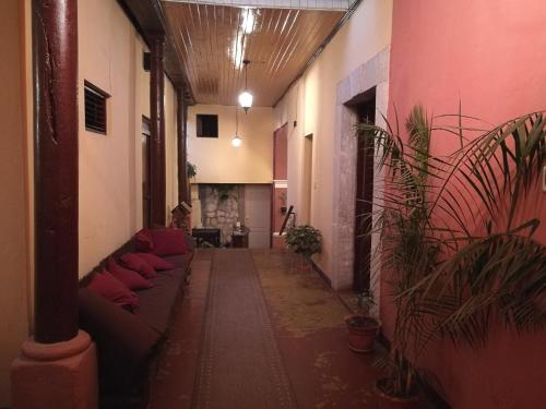 克萨尔特南戈Hotel Casa Quetzaltenango的大楼内带有长沙发和植物的走廊