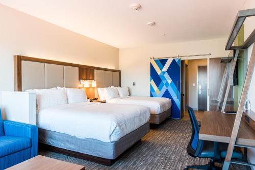 麦迪逊麦迪逊智选假日套房酒店的酒店客房,设有两张床和一张蓝色椅子