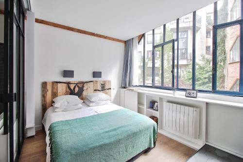 巴黎Sloth Loft Montmartre的一间卧室设有一张床和大窗户