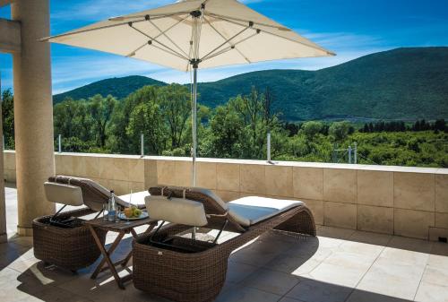 布德瓦奥迪西酒店的庭院配有桌椅和遮阳伞。