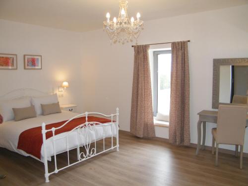 皮斯甘Clos Vieux Rochers Vineyard的一间卧室配有一张床、一张桌子和一个吊灯。