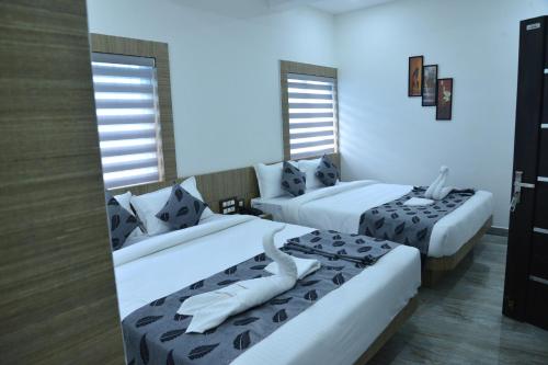 维拉杰佩特Suroor Tourist Home的酒店客房带两张床和两个窗户