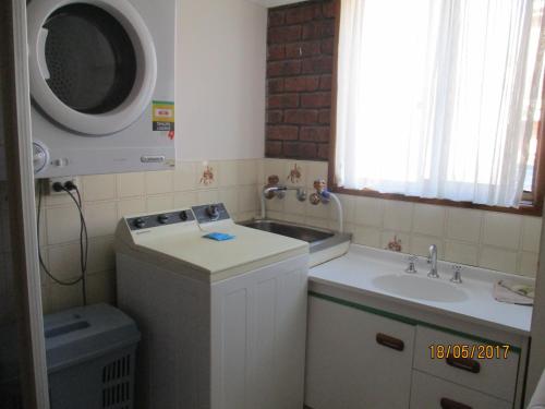 梅林布拉海港之光假日公寓的一间带水槽和洗衣机的小浴室