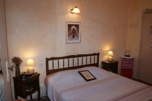 Moulins-la-Marche海豚酒店的卧室配有一张挂在墙上的床铺