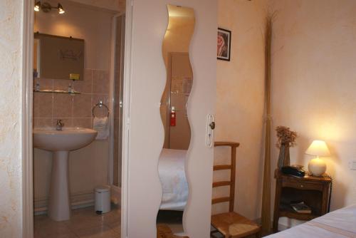 Moulins-la-Marche海豚酒店的客房内设有带水槽和淋浴的浴室