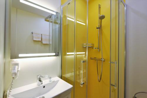 圣沃尔夫冈西雀瓦伯酒店的一间带水槽和玻璃淋浴的浴室