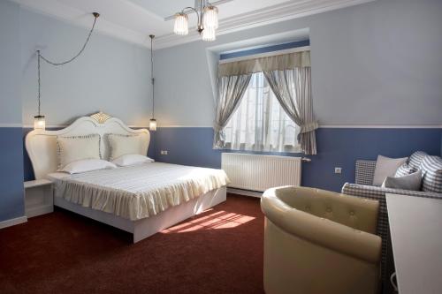 舒门Green Palace Hotel的一间卧室配有一张床、一张沙发和一把椅子