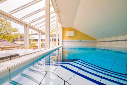 居斯特罗因瑟尔斯库尔豪斯酒店的一个带大窗户的室内游泳池